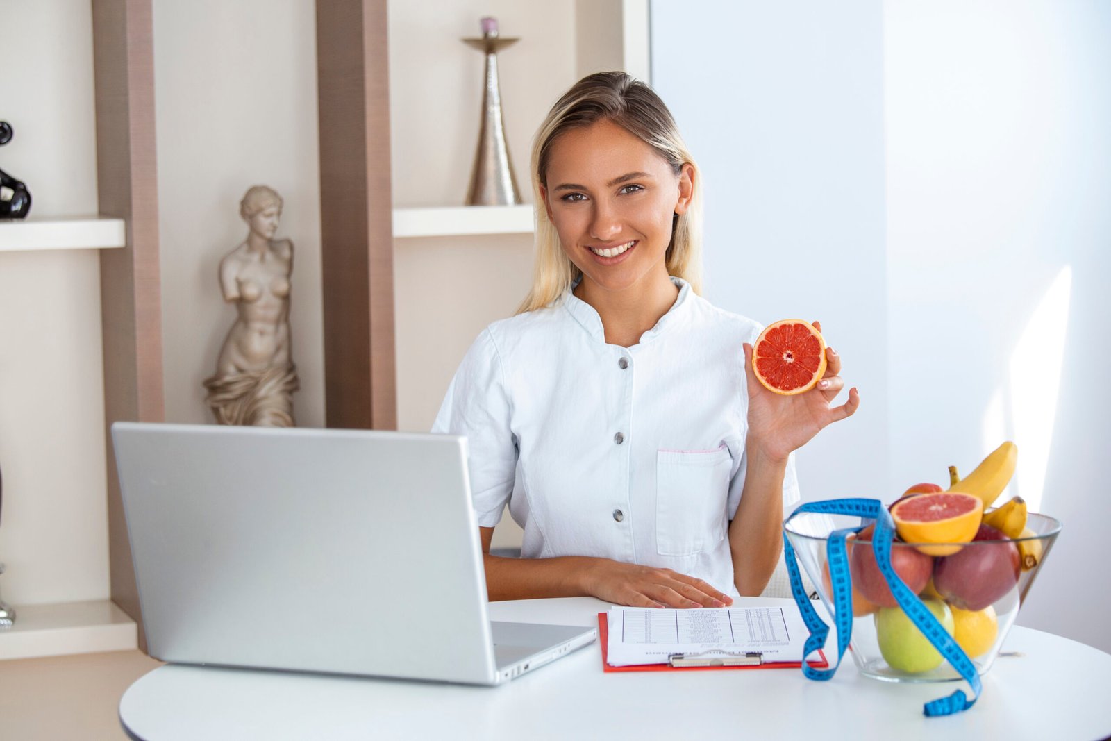 Smiling Nutritionist Her Office She Is Showing Healthy Vegetables Fruits Healthcare Diet Concept Female Nutritionist With Fruits Working Her Desk Scaled