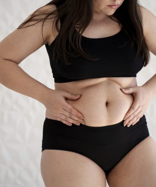 front-view-young-woman-holding-her-belly